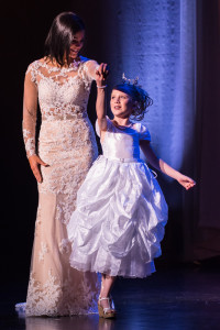 A contestant for Miss Utah 2015 spins her young escort.
